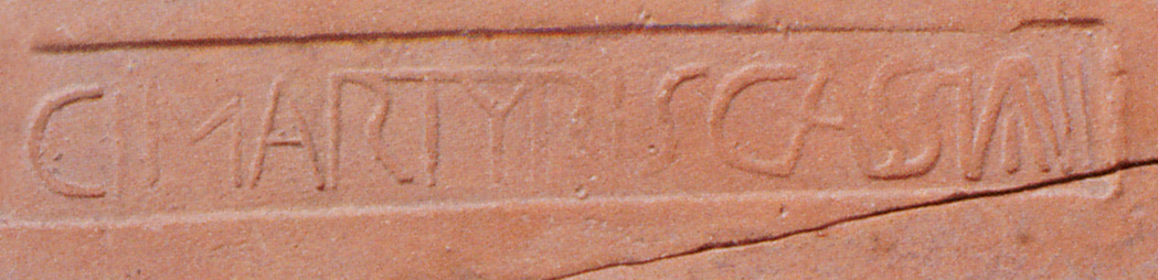 Frammento di tegola con bollo intitolato  a Cassiano, forse proveniente dal sacello del santo martire.
Fragment of a roof tile with  stamp titled to Cassianus, perhaps  from the sacellum of the saint martyr.
